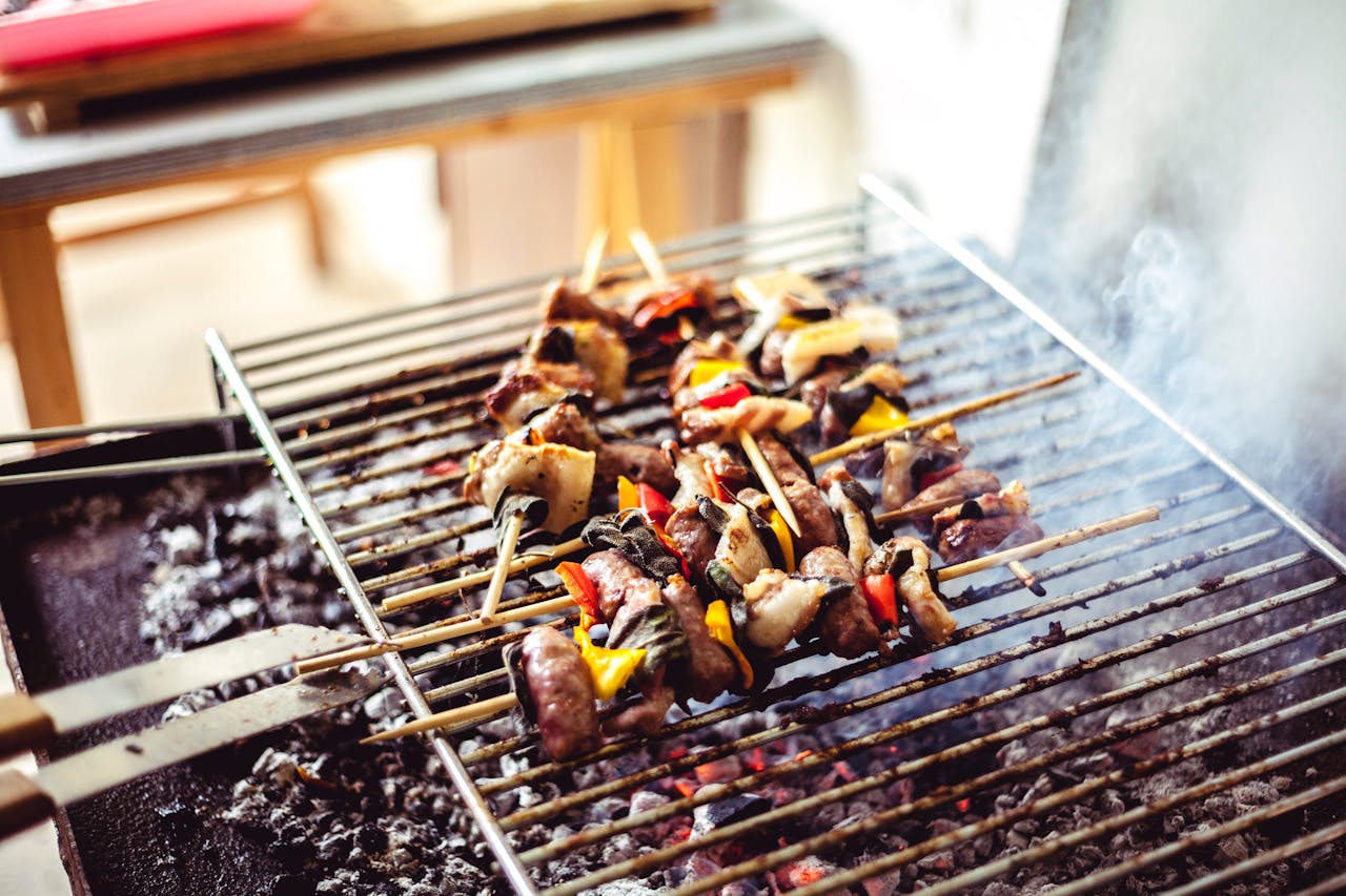 why-choose-me Savory grilled skewers with meat and vegetables sizzling over hot charcoal, perfect for outdoor cooking.